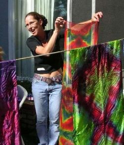 Shyannon pulling fresh-dyed scarf off line in shibori workshop.