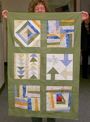 Mary Lou holding up green quilt